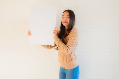 Güzel Asyalı genç kadınların portresi boş beyaz kağıt yaban domuzu gösteriyor.