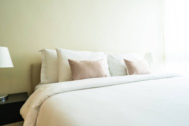 Yatak dekorasyonunda beyaz rahat yastık.