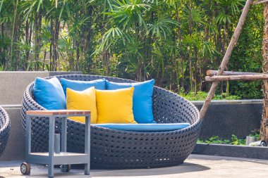 Bahçedeki verandada kanepe ve yastık dekorasyonu var.