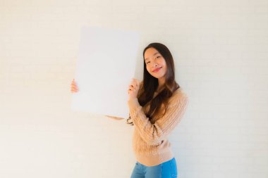 Güzel Asyalı genç kadınların portresi boş beyaz kağıt yaban domuzu gösteriyor.