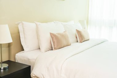 Yatak dekorasyonunda beyaz rahat yastık.