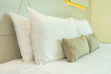 Yatak dekorasyonunda beyaz rahat yastık.