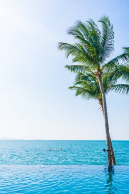 Otelin havuzunda hindistan cevizi palmiyeli lüks bir yüzme havuzu.