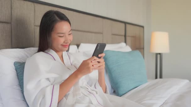 집에서 스마트폰을 사용하는 아시아 여성의 — 비디오