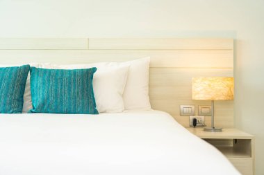 Yastık ve battaniye yatağın üzerinde, içinde lamba süslemesi var.