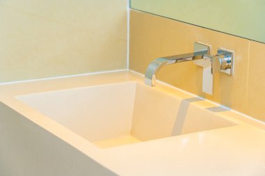 Banyoda musluk desenli beyaz lavabo.