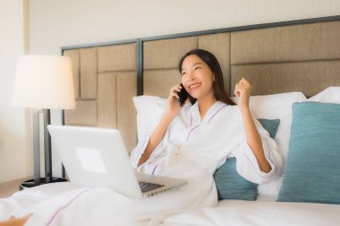 Laptop ya da bilgisayar kullanan güzel Asyalı kadınların portresi.