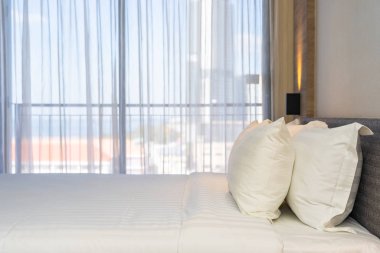 Yatak dekorasyonunda beyaz rahat yastık.