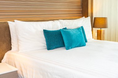 Yatak dekorasyonunda beyaz rahat yastık.