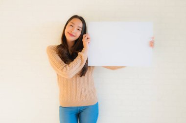 Güzel Asyalı genç kadınların portresi boş beyaz kağıt yaban domuzu gösteriyor.