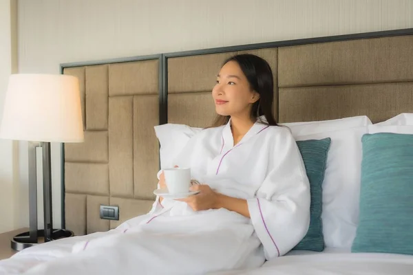 Portré gyönyörű fiatal ázsiai nők kávéscsésze az ágyon — Stock Fotó
