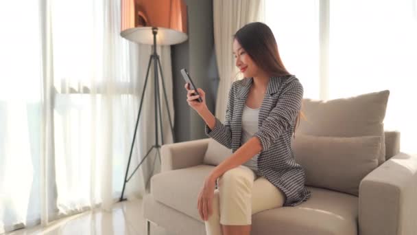 Beeldmateriaal Van Aziatische Vrouw Met Behulp Van Smartphone Thuis — Stockvideo