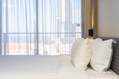 Yatak dekorasyonunda beyaz rahat yastık.