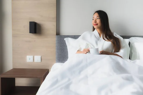 Porträt schöne junge asiatische Frauen mit Kaffeetasse auf dem Bett — Stockfoto