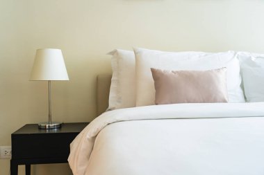 Yatak dekorasyonunda beyaz rahat yastık.