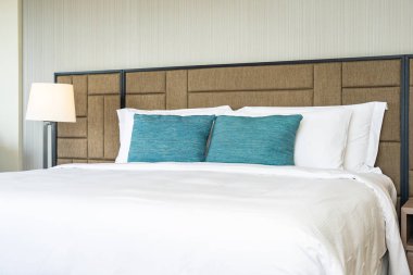 Yatak dekorasyonunda beyaz rahat yastık.