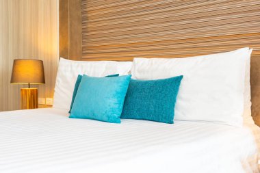 Yatak dekorasyonunda beyaz rahat yastık.