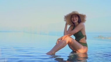 Güzel Asyalı bir kadının oteldeki havuzda dinlenirken çekilmiş görüntüleri.