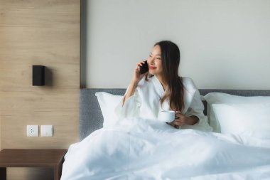 Güzel Asyalı genç kadınların portresi Kahveyle mutlu bir gülümseme ve