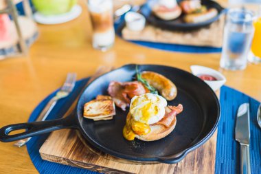 Sıcak tavada yumurtalı Benedict sosisi ile kahvaltı.