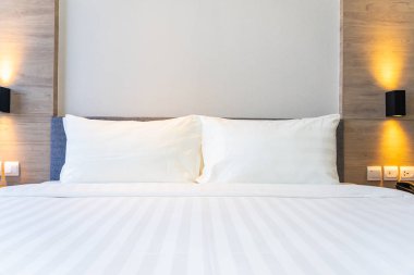 Yatak dekorasyonunda beyaz rahat yastık.