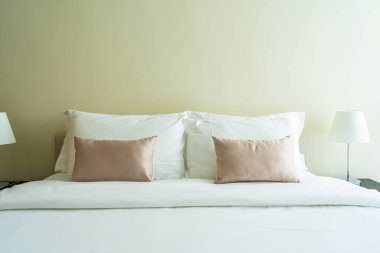 Yatak dekorasyonunda beyaz rahat yastık.