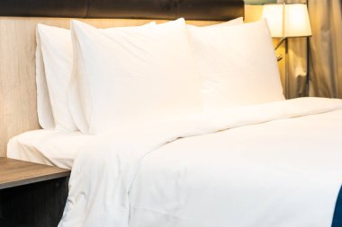 Yatak odasındaki beyaz rahat yastık ve battaniye