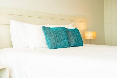 Yastık ve battaniye yatağın üzerinde, içinde lamba süslemesi var.