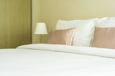 Yatak dekorasyonunda beyaz rahat yastık.