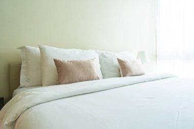 Yatak dekorasyonunda beyaz rahat yastık.