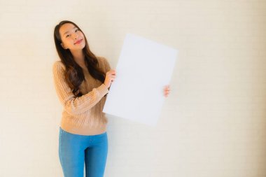 Güzel Asyalı genç kadınların portresi boş beyaz kağıt yaban domuzu gösteriyor.