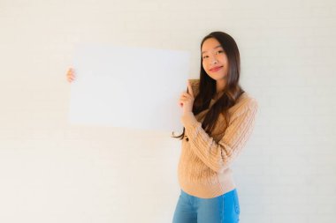 Güzel Asyalı genç kadınların portresi boş beyaz kağıt yaban domuzu gösteriyor.