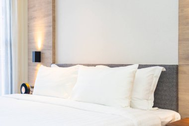 Yatak dekorasyonunda beyaz rahat yastık.