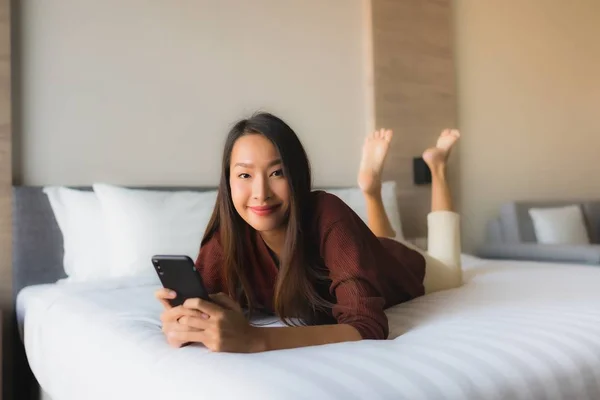 Porträt schöne junge asiatische Frauen mit Handy auf dem Bett — Stockfoto