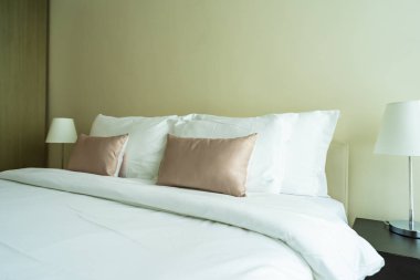 Yatak dekorasyonunda beyaz rahat yastık.