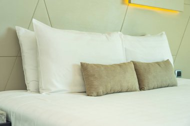 Yatak dekorasyonunda beyaz rahat yastık.