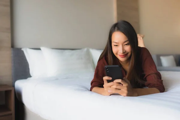 Portrait belles jeunes femmes asiatiques en utilisant le téléphone mobile sur le lit — Photo