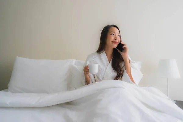 Porträt schöne junge asiatische Frauen mit Kaffeetasse und Handy — Stockfoto