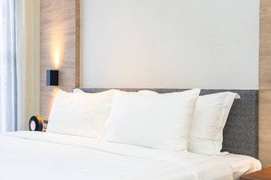 Yatak dekorasyonunda beyaz rahat yastık.