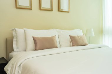 Yatak dekorasyonunda beyaz rahat yastık.