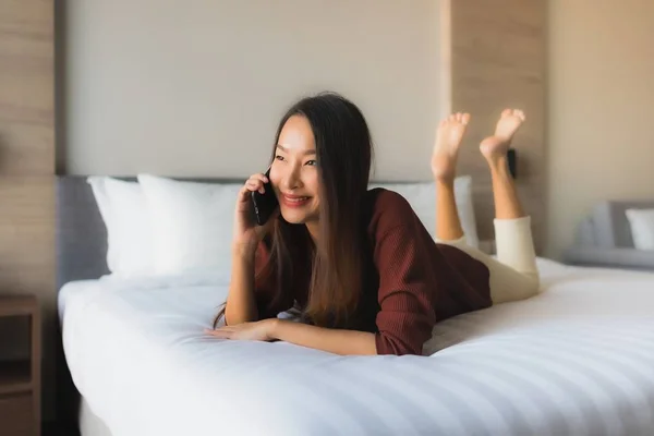 Porträt schöne junge asiatische Frauen mit Handy auf dem Bett — Stockfoto