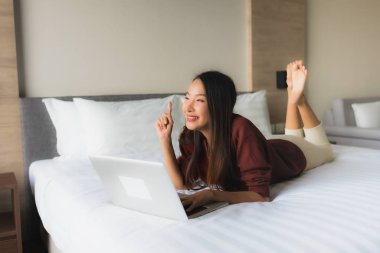 Bilgisayar ve cep telefonu kullanan güzel Asyalı genç kadınların portresi.