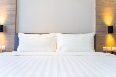 Yatak dekorasyonunda beyaz rahat yastık.