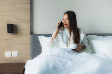 Güzel Asyalı genç kadınların portresi Kahveyle mutlu bir gülümseme ve