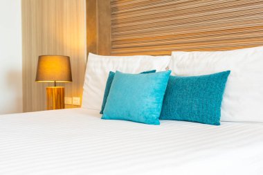 Yatak dekorasyonunda beyaz rahat yastık.