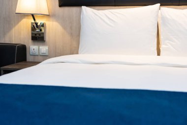 Yatak odasındaki beyaz rahat yastık ve battaniye