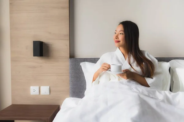 Ritratto belle giovani donne asiatiche con tazza di caffè sul letto — Foto Stock