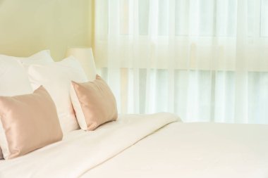 Yatak dekorasyonunda beyaz rahat yastık.