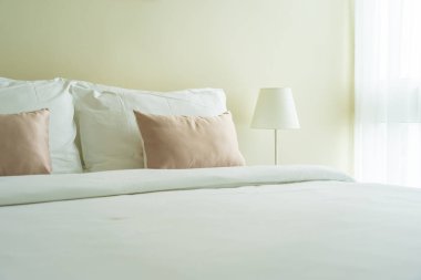 Yatak dekorasyonunda beyaz rahat yastık.