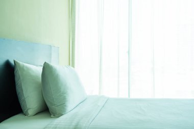 Yastık ve battaniye yatağın üzerinde, içinde lamba süslemesi var.